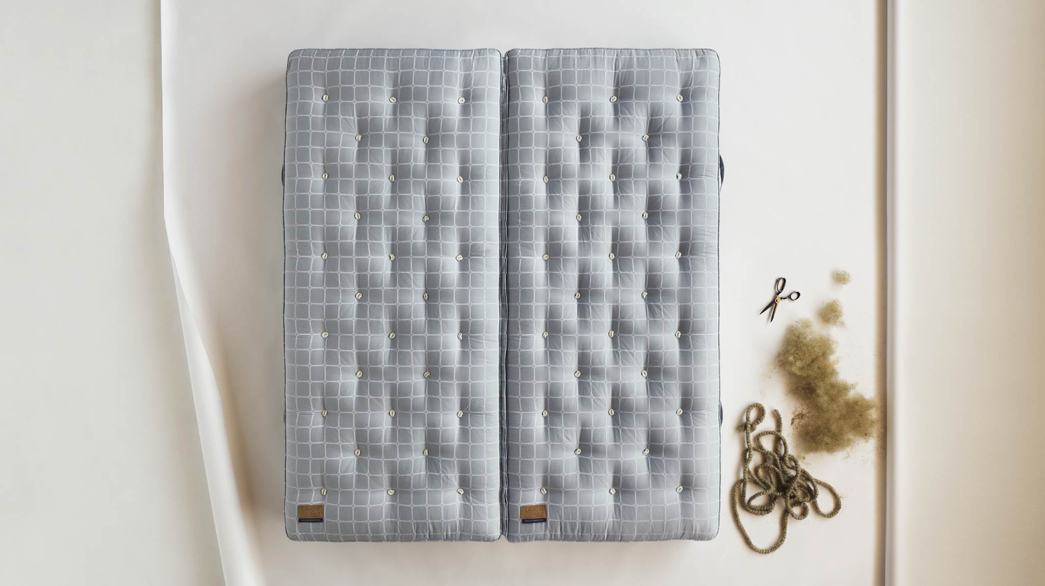 Image of a Savoir mattress laid on the floor with its ingredients next to it.