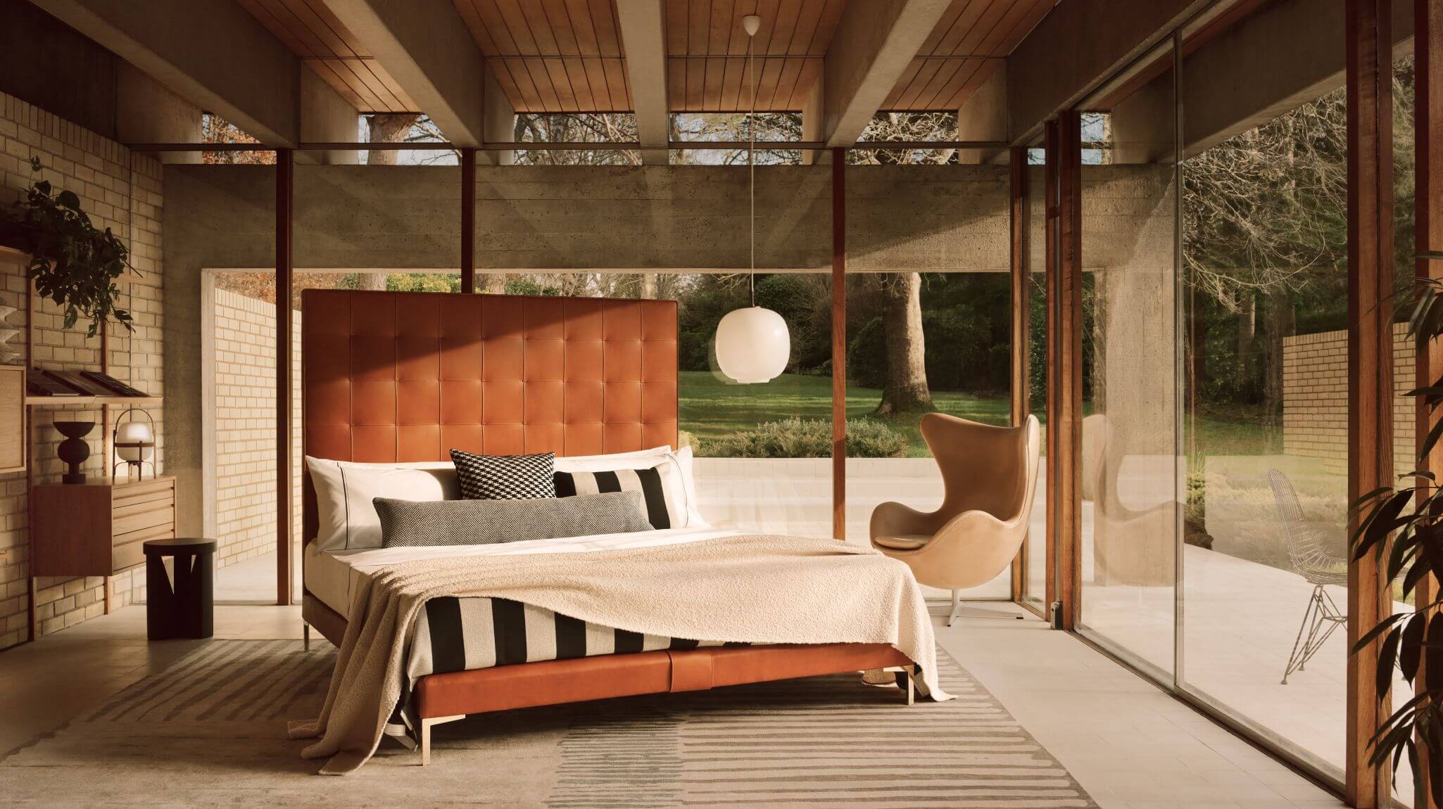 The mid-century inspired Winston headboard with a slim base, upholstered in rich tan leather and finished with angled metal legs