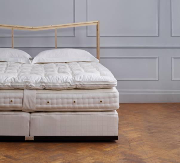Savoir bed featuring the no1 base, the mattress, the topper and cushions with our naked headboard
